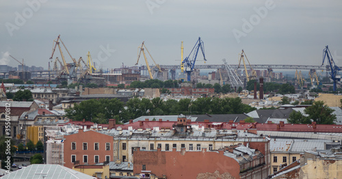 View on Saint Petersburgs' roofs from a cathedral height. Saint Petersburg in different directions. Cranes of a port