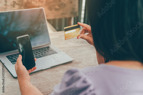 Online payment, hands holding a credit card and using smart phone for online shopping
