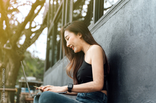 Young woman holding credit card and using laptop computer. Businesswoman working at home. Online shopping, e-commerce, internet banking, spending money, working from home concept