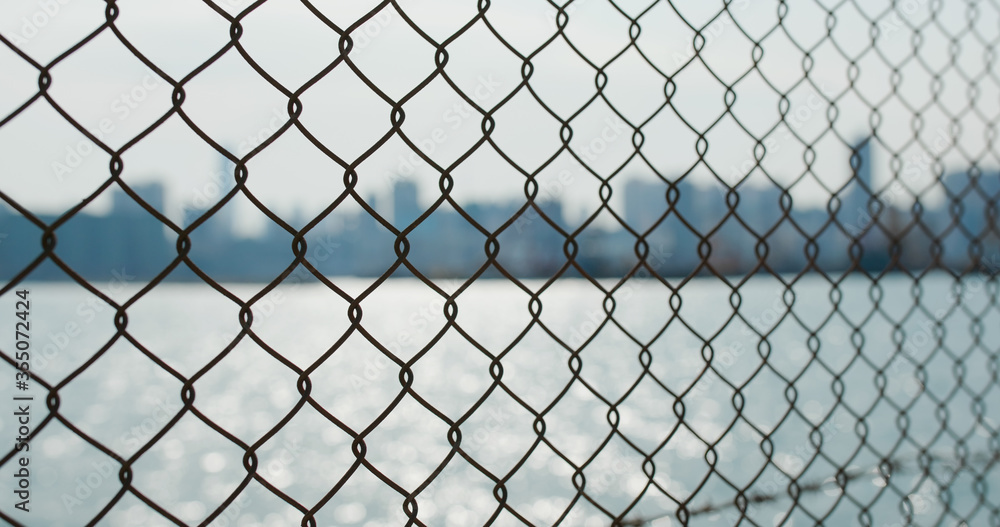 Fototapeta premium Metallic fencing at seaside in evening