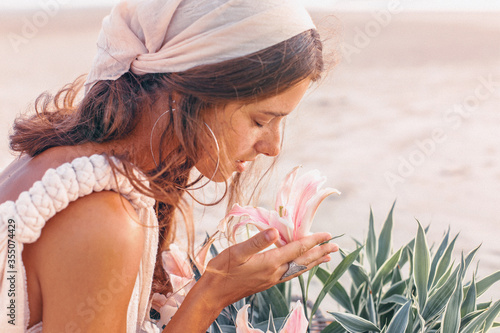 beautiful young stylish woman with basket with flowers outdoors at sunset close up portrait