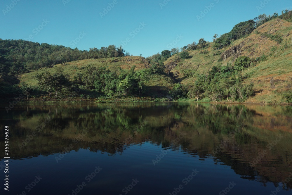 Landscape view of a hill and lake with clear blue skies.