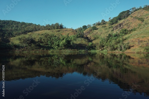 Landscape view of a hill and lake with clear blue skies.