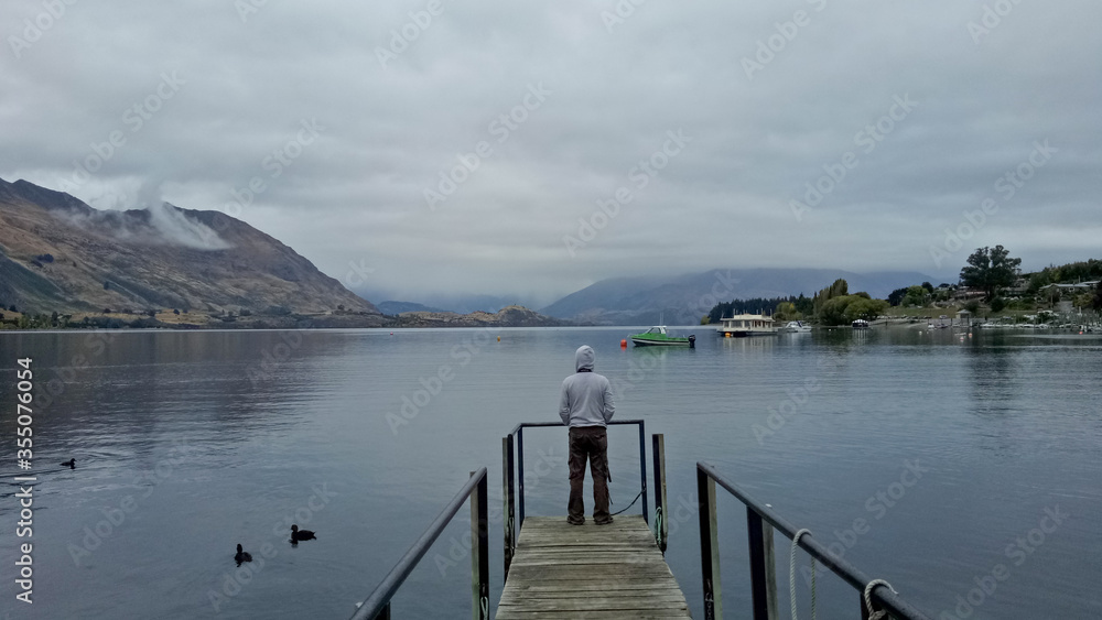 A man standing near lake Wanaka New Zealand