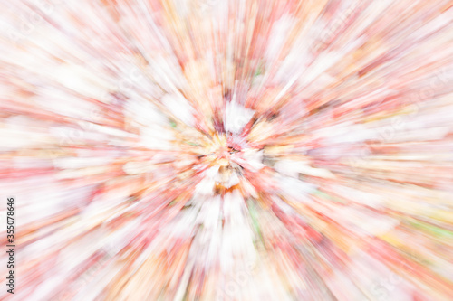 Abstract fall colors in zoom blur presenting bright converging pattern.