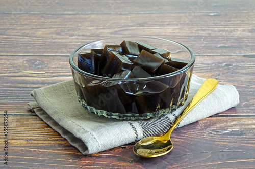 Grass jelly, or leaf jelly or herb jelly, is a jelly-like dessert eaten in East Asia. It is created by using the herbs name Platostoma palustre. Dessert of Summer. Selective focus, space for texts photo