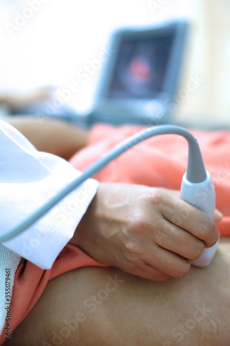 Physician making echocardiography for male patient heart by using ultrasound probe press on patient’s breast