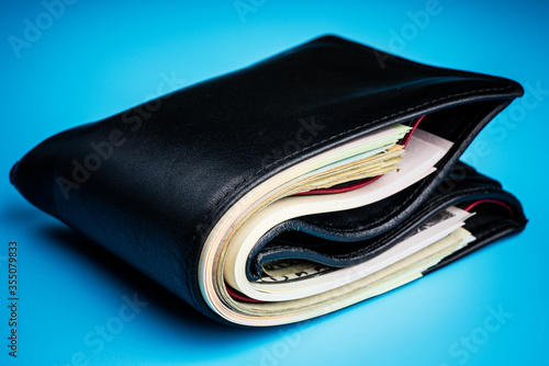 leather wallet with money on blue background