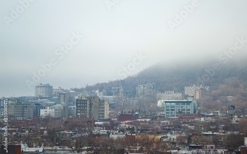 View of the part of the ascent of mount Royal, which is closer to Down Town, taken on a long lens from the side of the Plateau area from the 10th floor. The mountain is covered with mist by half