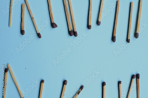 Scattered matches stick on a blue background with copyspace. Top view. 