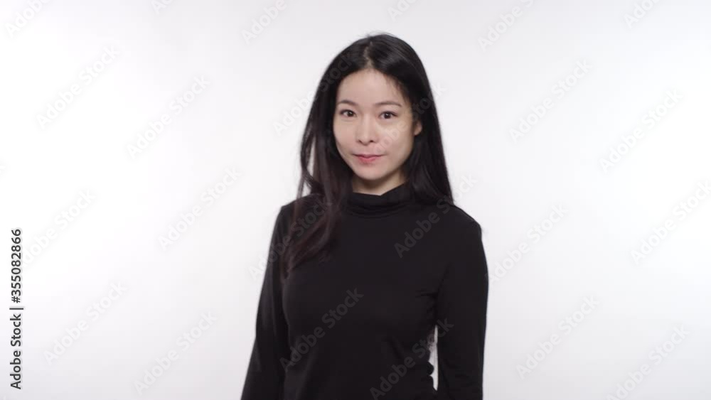 Woman of Asian descent smiling and laughing on a white studio backdrop Woman of Asian descent smiling and laughing on a white studio backdrop