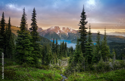 Bild auf Leinwand Glacial mountain Garibaldi lake with turquoise water in the middle of coniferous forest at sunset
