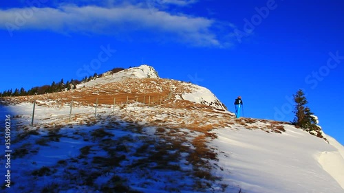 Woman at the top of themountain alone at winter sunset. photo