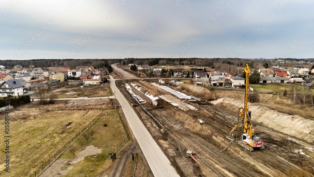 Zabiezki, Poland, 2020. Aerial view on railway line construction site in small village near Otwock and Warsaw. Railway components ready to deploy. Train tracks underlay and concrete ties.