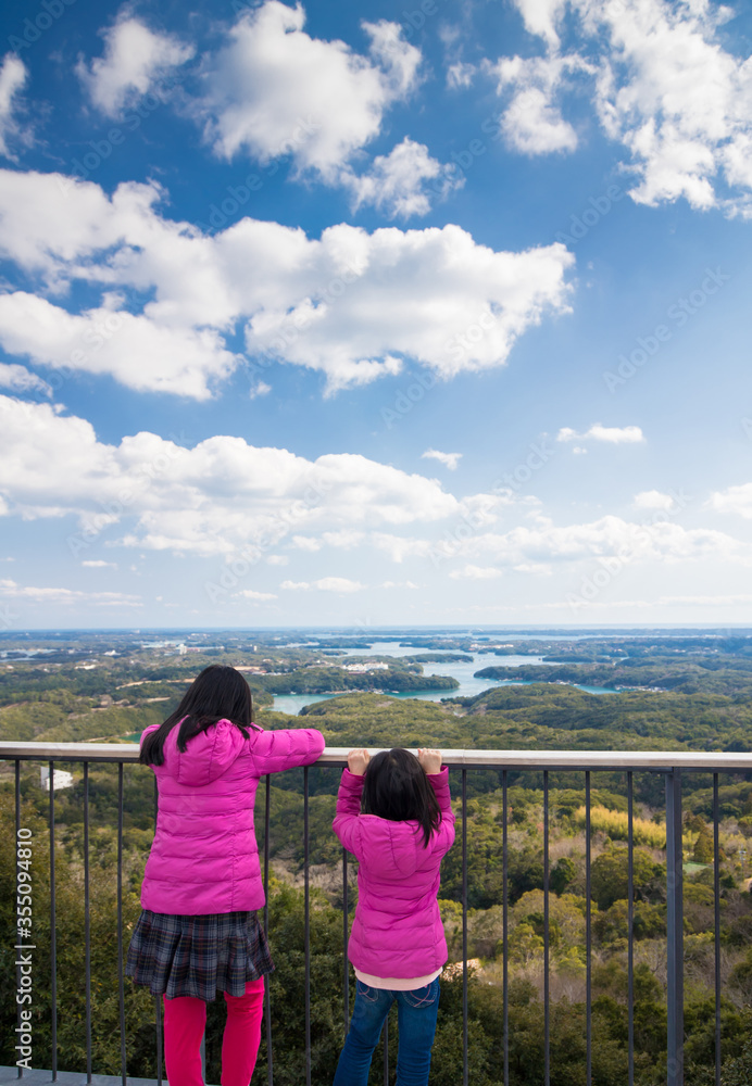 三重県志摩市横山展望台で伊勢志摩国立公園の風景を見ている子供姉妹