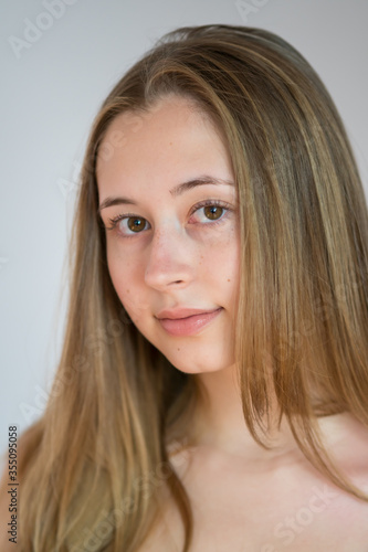 Close up portrait of a pretty teenage girl smiling looking at the camera. Studio shot