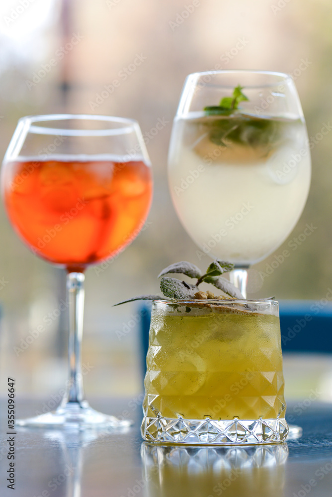 Three colorful refreshing cocktails served on a dark rustic wooden table with blurred background. Three colorful refreshing cocktails served on a dark rustic wooden table with blurred background.