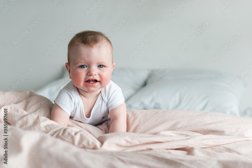 Cute, beautiful little baby lying on his tummy in bed with pink lingerie Cute, beautiful little baby lying on his tummy in bed with pink lingerie
