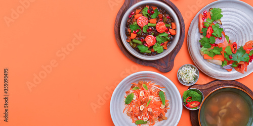 Lenten menu dishes assortment. Different healthy vegetable salads. Bright orange background. Flat lay. Top view.