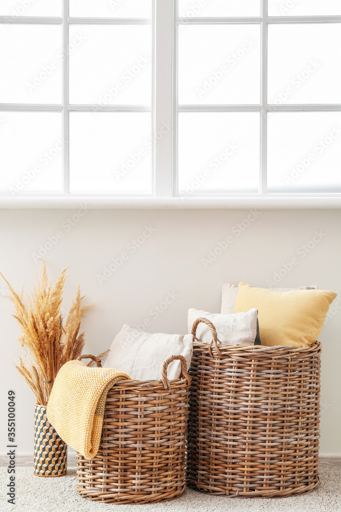 Fototapeta premium Wicker baskets with pillows and plaid in room