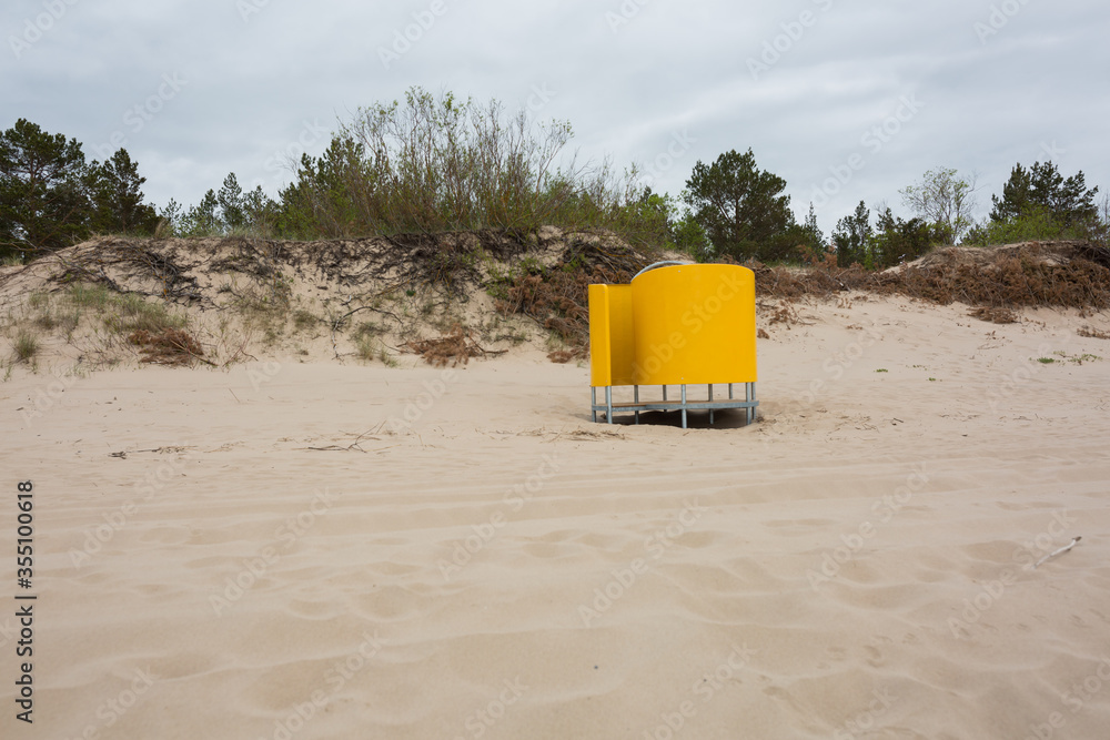 There is an outdoor dressing room in the sand by the sea. There is an outdoor dressing room in the sand by the sea.