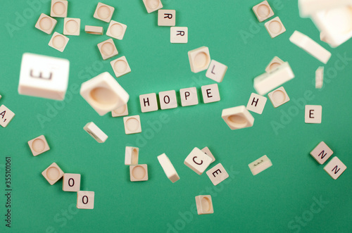 green background with scrabble pieces with the word hope and pieces falling photo