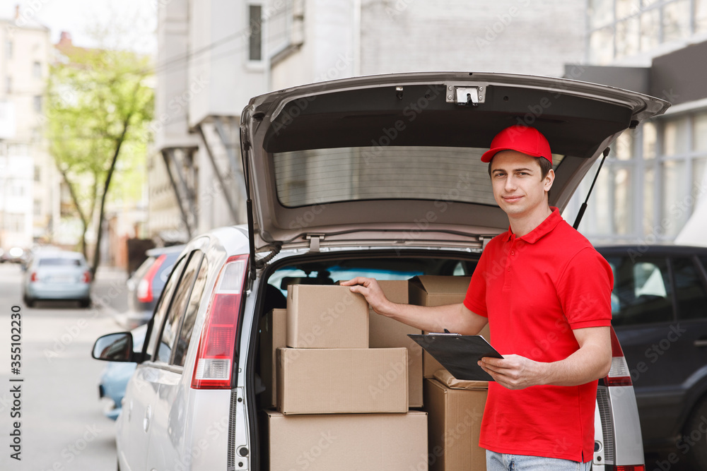 Checking packages in car. Auto delivery with courier to home Checking packages in car. Auto delivery with courier to home