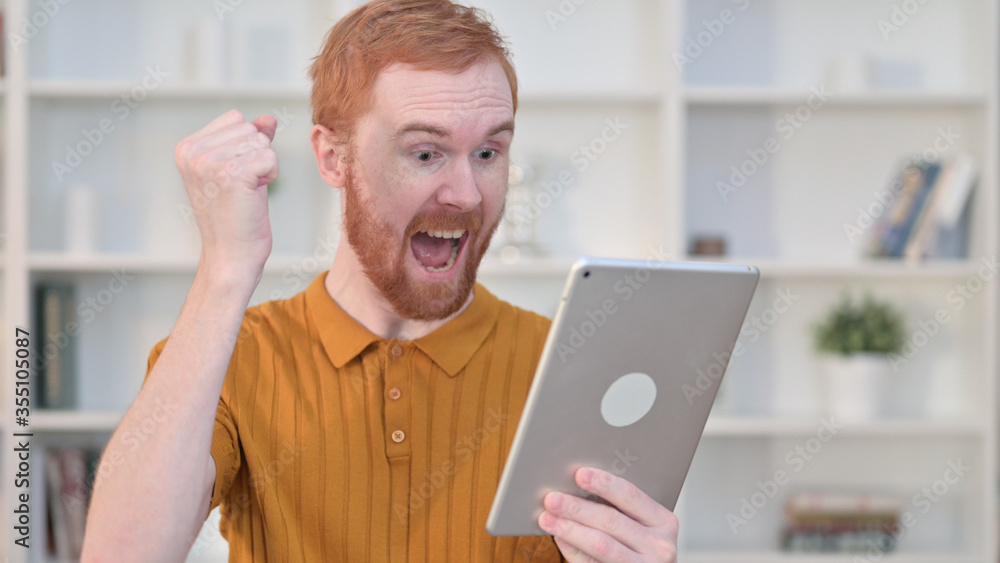 Portrait of Redhead Man Celebrating Success on Tablet Portrait of Redhead Man Celebrating Success on Tablet