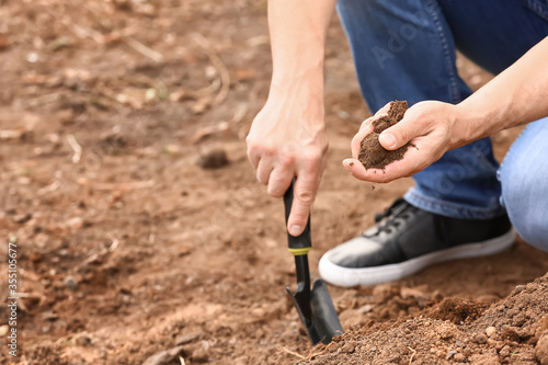 Man testing rich soil outdoors