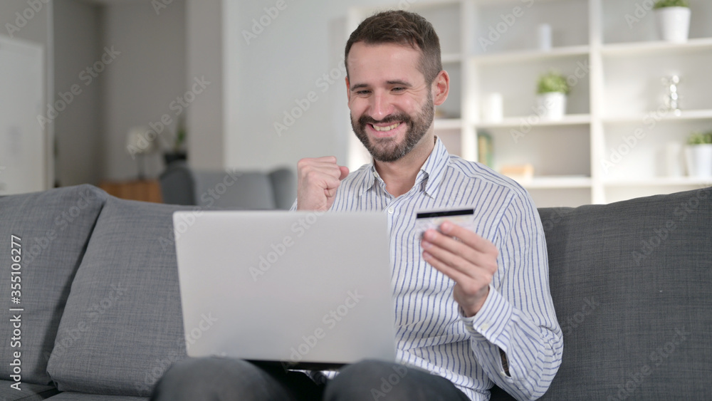 Successful Online Payment on Laptop by Happy Man at Home Successful Online Payment on Laptop by Happy Man at Home