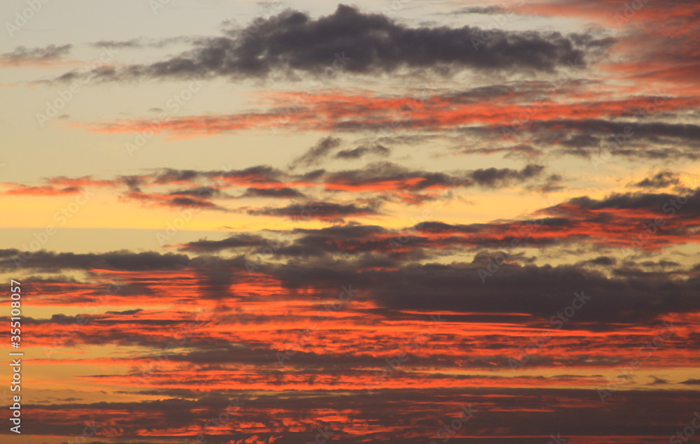 Fototapeta premium Deep red clouds and warm colored sky at sunset