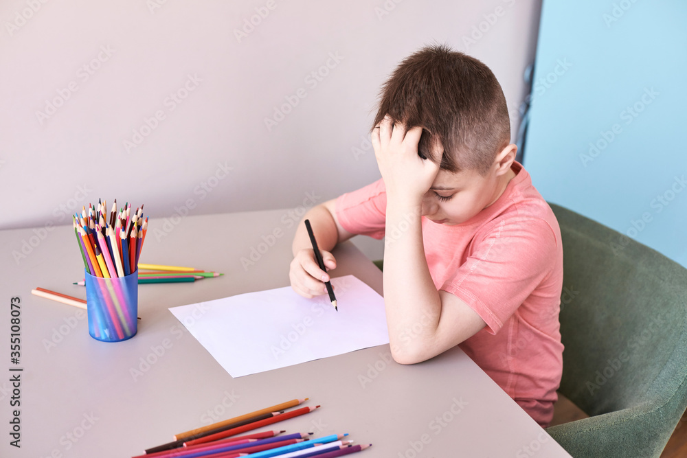 Little boy drawing. Closed Locking Exercise. Homemade routine. School lessons. Write pencil on piece of paper. Home study. Elementary preschool. Male kid student. Thinking or dreaming Little boy drawing. Closed Locking Exercise. Homemade routine. School lessons. Write pencil on piece of paper. Home study. Elementary preschool. Male kid student. Thinking or dreaming