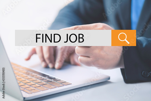 .Business man click on virtual button with text find job and working with laptop.Job on-line concept.