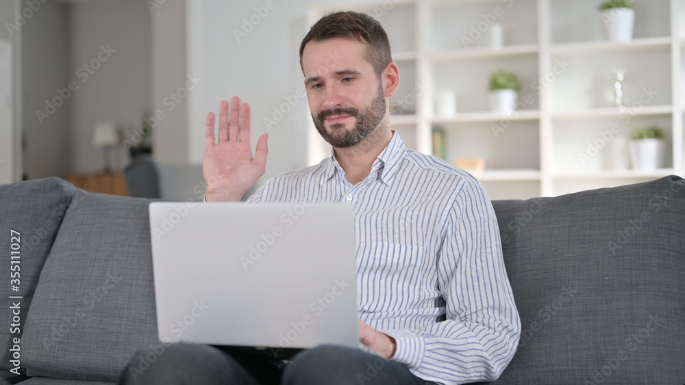 Cheerful Young Man doing Video Chat on Laptop at Home Cheerful Young Man doing Video Chat on Laptop at Home
