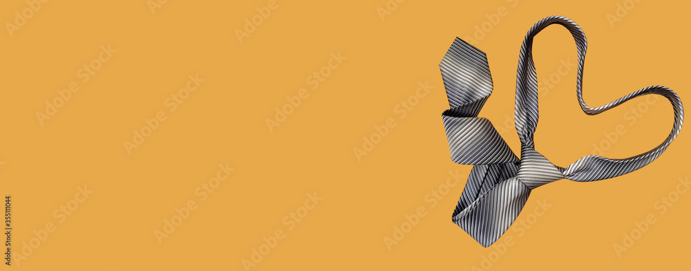 Men's necktie on the mustard color background. Heart shaped necktie. Banner with free space for text. Flat lay, top view. Fathers day banner Men's necktie on the mustard color background. Heart shaped necktie. Banner with free space for text. Flat lay, top view. Fathers day banner