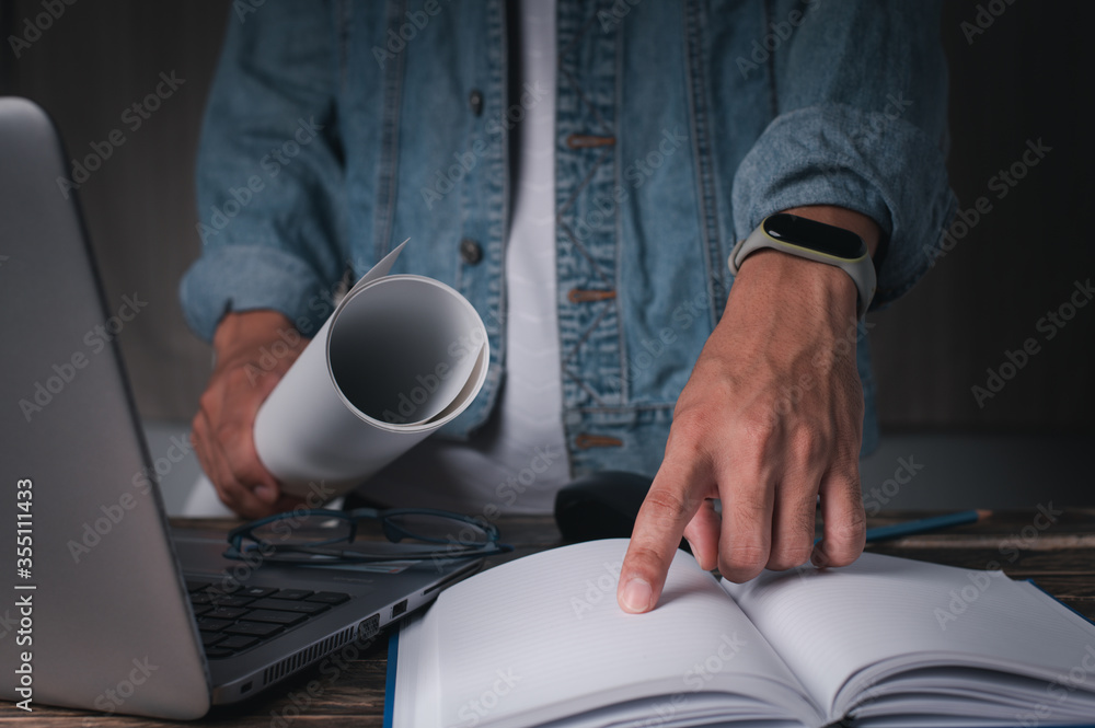 One man stood at work and used his index finger on the notebook. concept working at home , concept working in office. One man stood at work and used his index finger on the notebook. concept working at home , concept working in office.