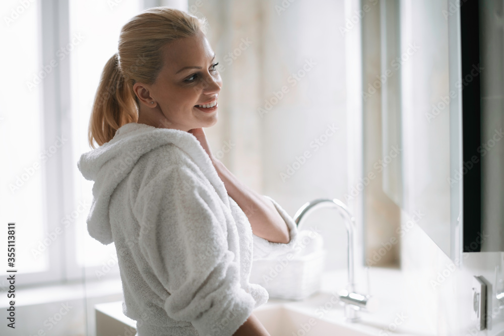 Beautiful woman enjoying in hotel. Young happy woman in bathrobe use the cream for the body.
Beautiful woman enjoying in hotel. Young happy woman in bathrobe use the cream for the body.
