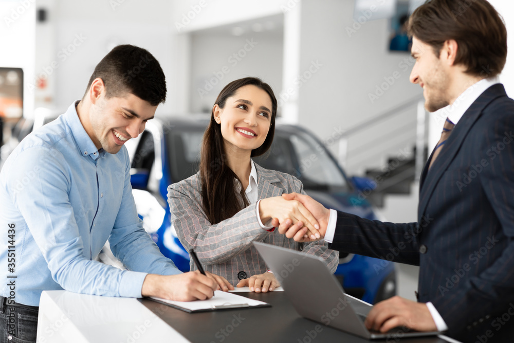 Spouses Buying Car And Handshaking With Seller Man Spouses Buying Car And Handshaking With Seller Man