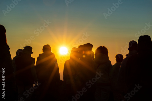 A group of people greeting the sunrise