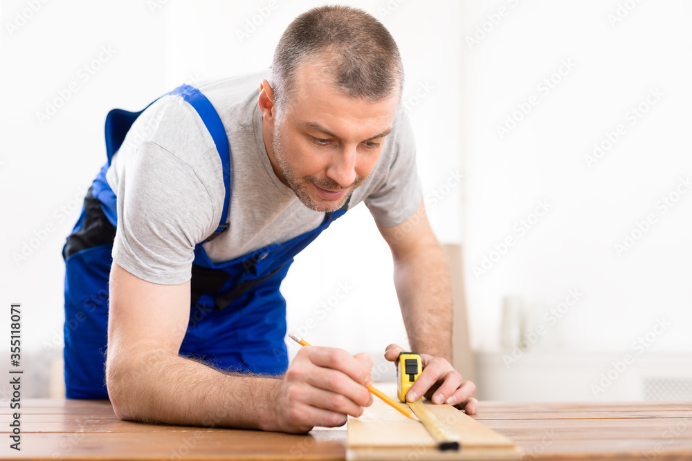 Professional Carpenter Measuring Wooden Board Working Indoors, Selective Focus Professional Carpenter Measuring Wooden Board Working Indoors, Selective Focus