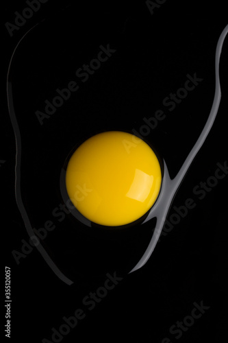 Top view of broken egg on black background