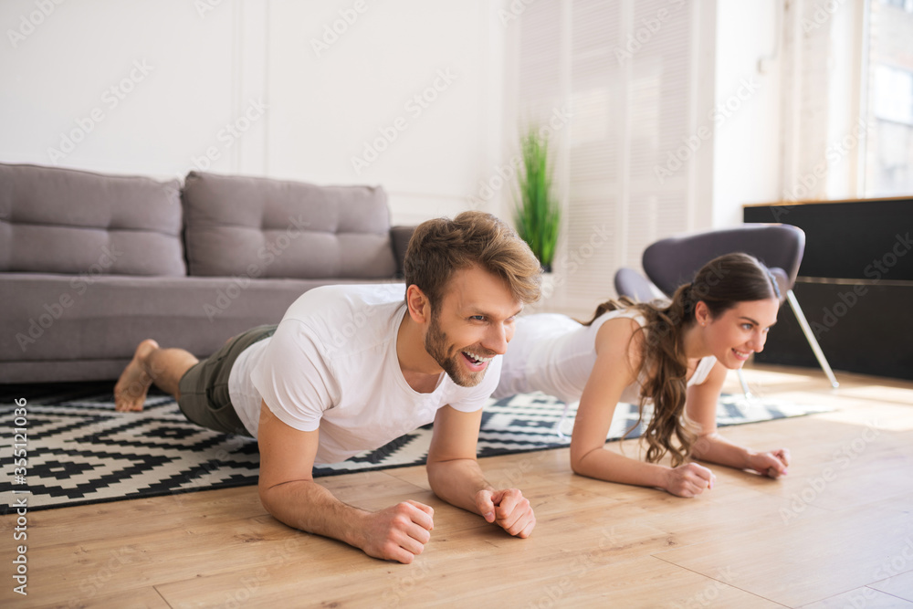 Young couple standing in plank and feeling good Young couple standing in plank and feeling good