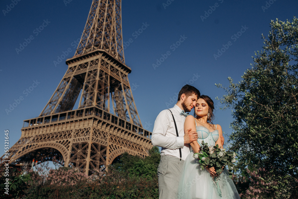 A bride and groom having a romantic moment on their wedding day in Paris, against the backdrop of the Eiffel tower.