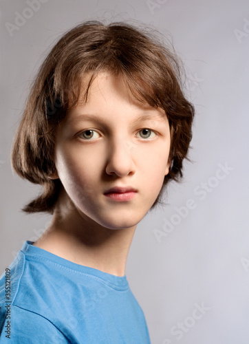 Portrait of a Teenage Boy with Brown Hair in Blue Top.