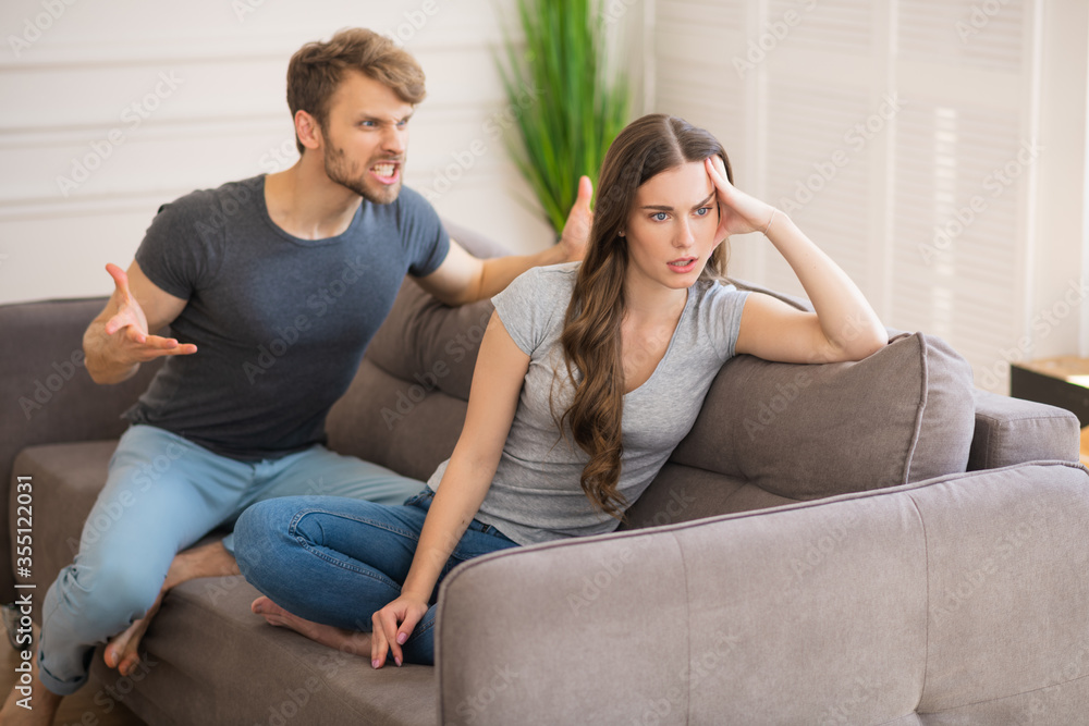 Young bearded man shouting on his wife while she turning her back to him Young bearded man shouting on his wife while she turning her back to him