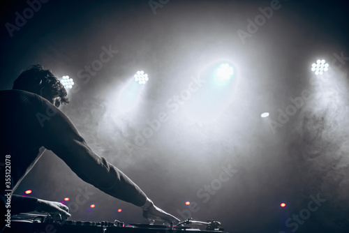 DJ in headphones plays at the club. disco. night life. atmosphere. black-and-white photo