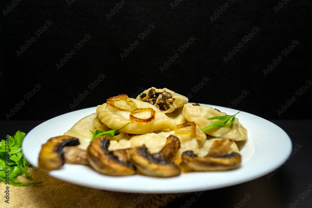 Dumplings with mushrooms, on a black background Dumplings with mushrooms, on a black background