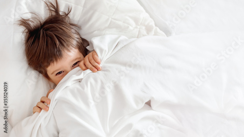 Cuadro en lienzo Cute toddler hides in bed