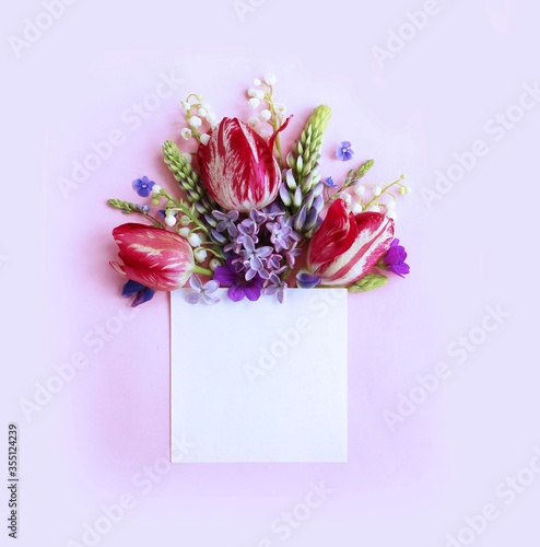 Spring flower arrangement in pink tones. A sheet of writing paper framed with spring flowers. Background for postcards, invitations, and greetings. photo