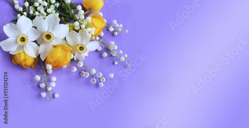 Bright spring flower arrangement. Yellow flowers of trolius europaeus and white daffodils on a lilac background. Bright light colors. Background for spring greeting cards, invitations photo